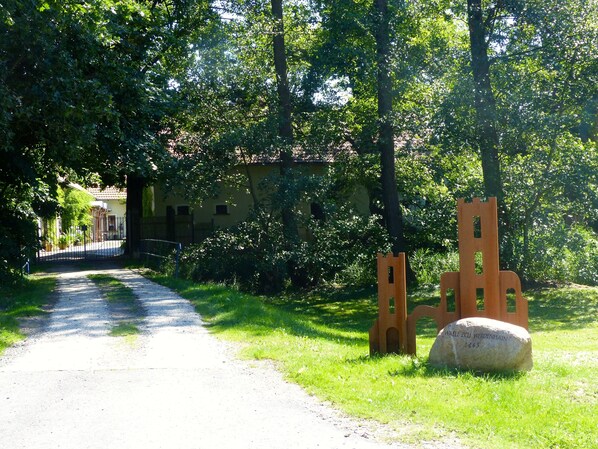 A rural road leading to a yellow house with a metal gate. - vacation on the farm (Röderland)
