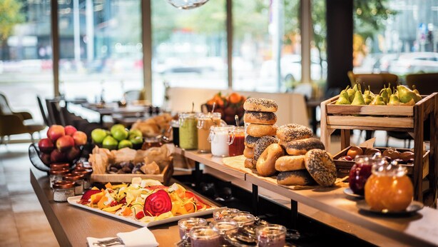 A breakfast buffet with various fruits, pastries, and beverages. - MOOONS (Vienna)
