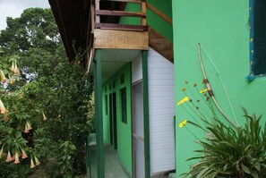 A narrow corridor with green walls and a wooden balcony. - Pousada Recanto Verde (Sao Benedito do Sul)