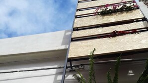 A modern building with a white facade and a sloped roof. - Community Rooms & Wine (Favara)
