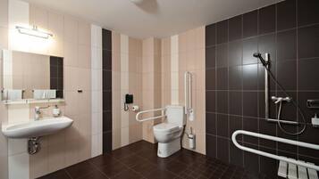Een moderne badkamer met een wit wastafel, toilet, douchegedeelte en een handgreep.