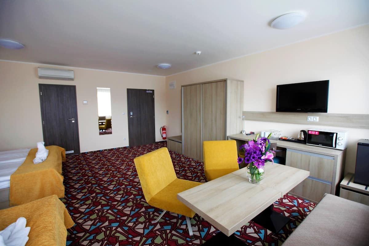 deluxe quadruple room, 2 queen beds | living area | flat-screen tv