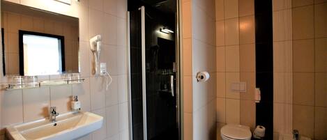 Un baño moderno con lavamanos, inodoro, bidé y cabina de ducha de cristal.