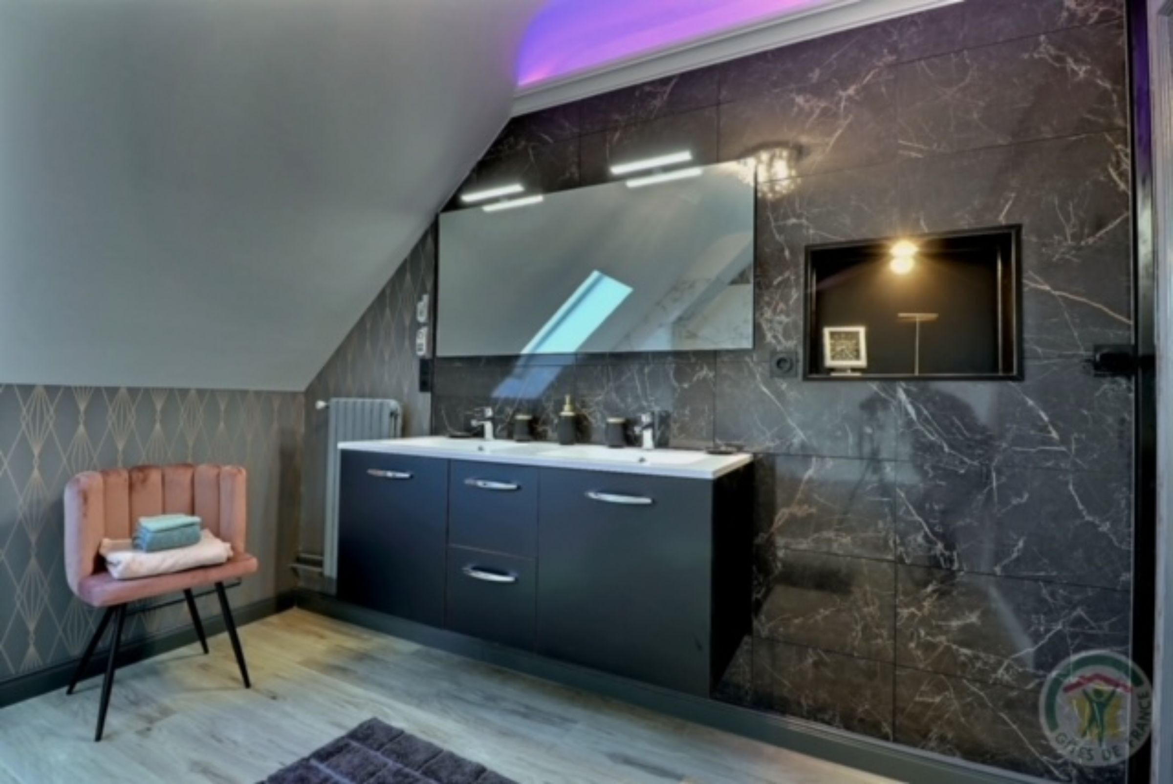 Un baño moderno con tocador, espejo y un estante pequeño.