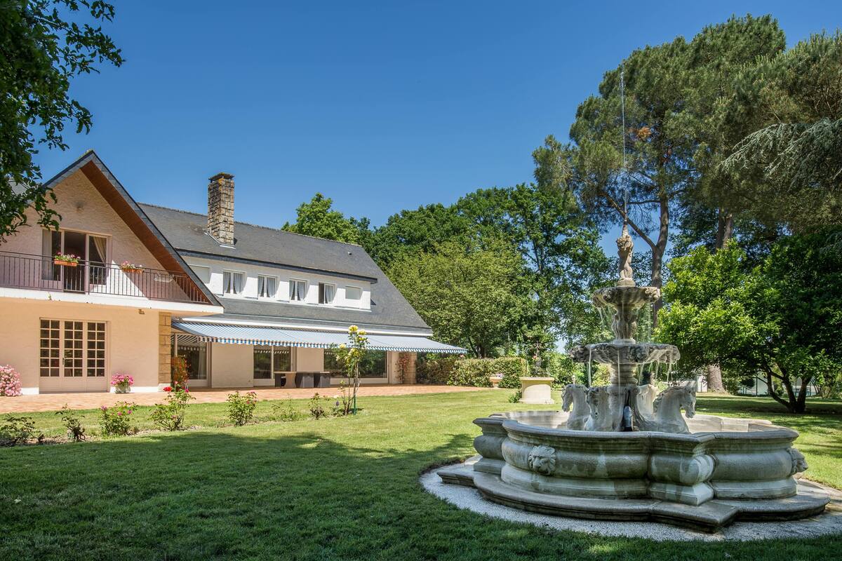 A house with a large garden and a fountain.