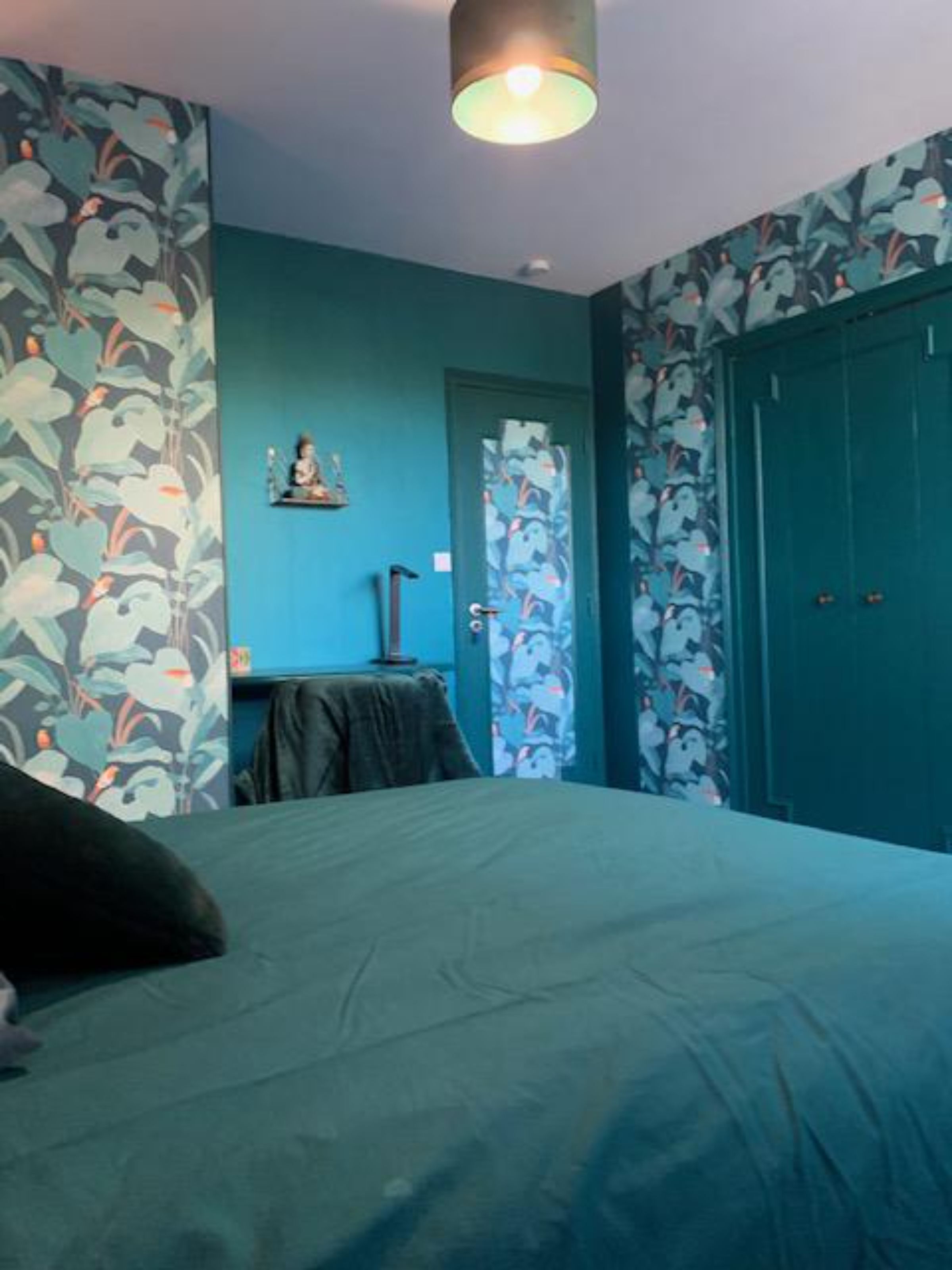 Ein Schlafzimmer mit Bett, Schreibtisch und Kleiderschrank.