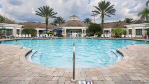 A swimming pool with a 3 FT safety barrier, surrounded by lounge chairs and palm trees. - Our Happy Place by VillaDirect (Kissimmee)