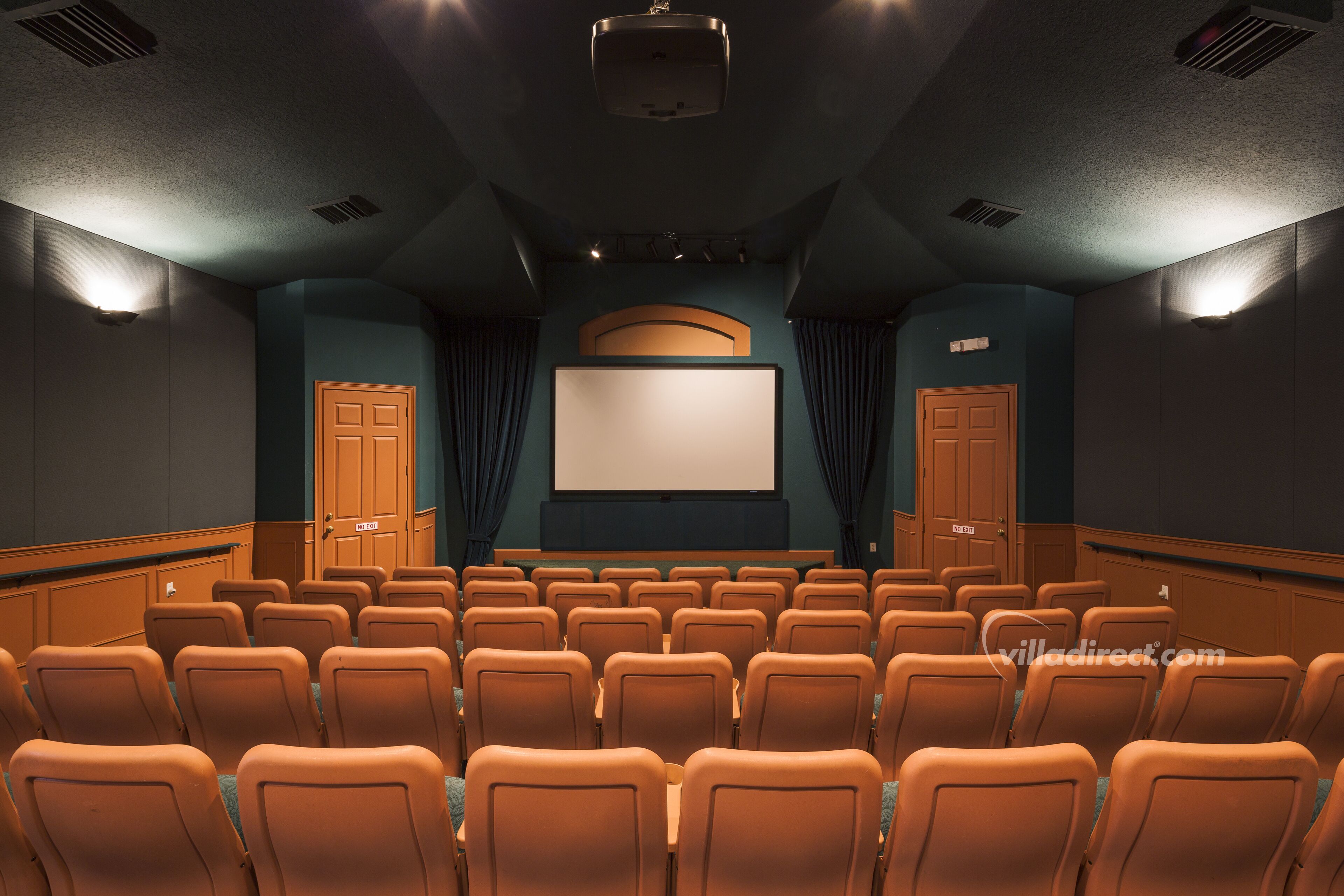 Un teatro con hileras de asientos, una pantalla grande y un proyector.