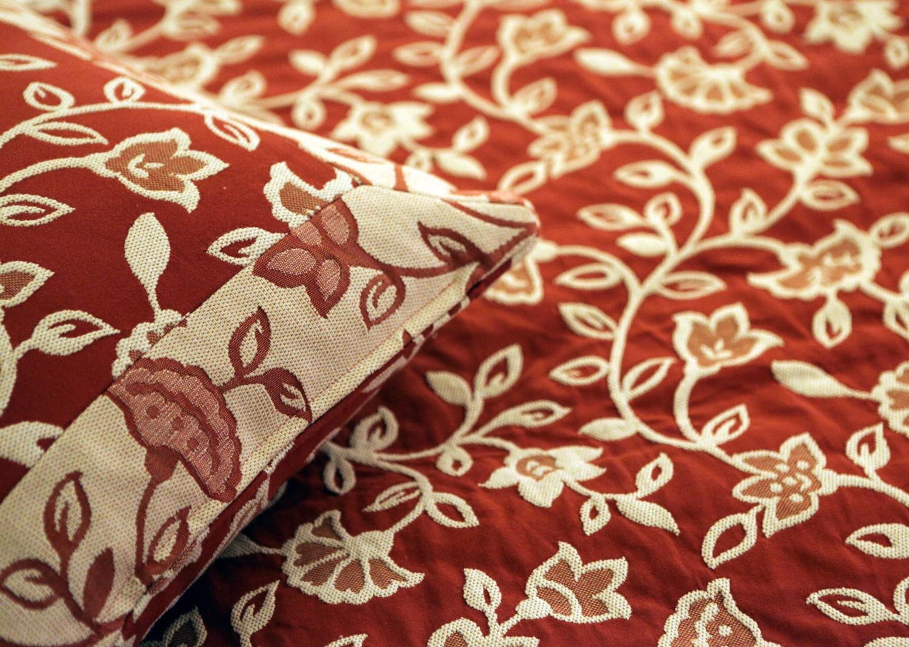 Primer plano de tela roja con estampado floral blanco.