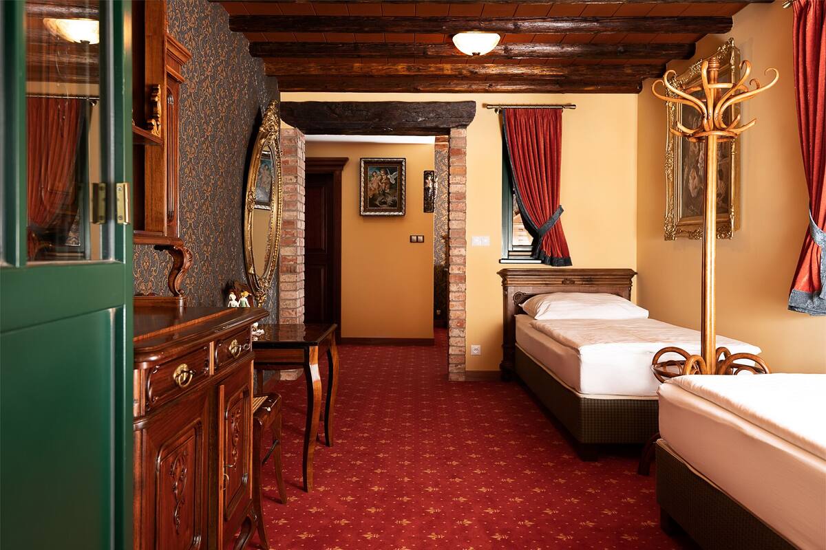 Una habitación con un tocador de madera, una cama, un escritorio y una silla.