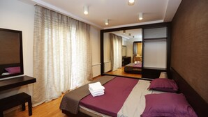 Una habitación de hotel moderna con una cama grande, un escritorio y un espejo.