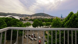 Un paisaje urbano que muestra un estacionamiento, edificios y una colina con una torre.