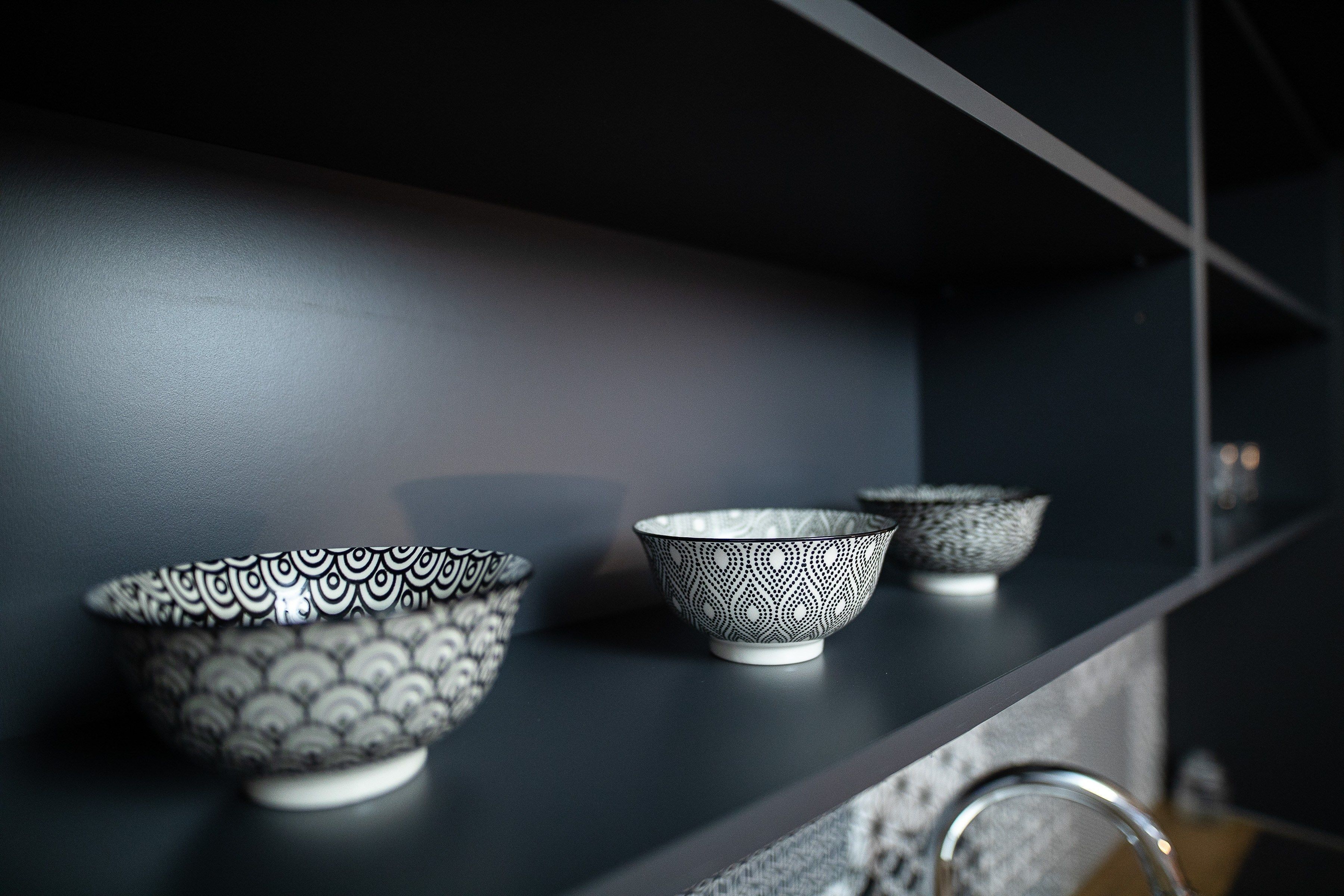A shelf with three patterned bowls.