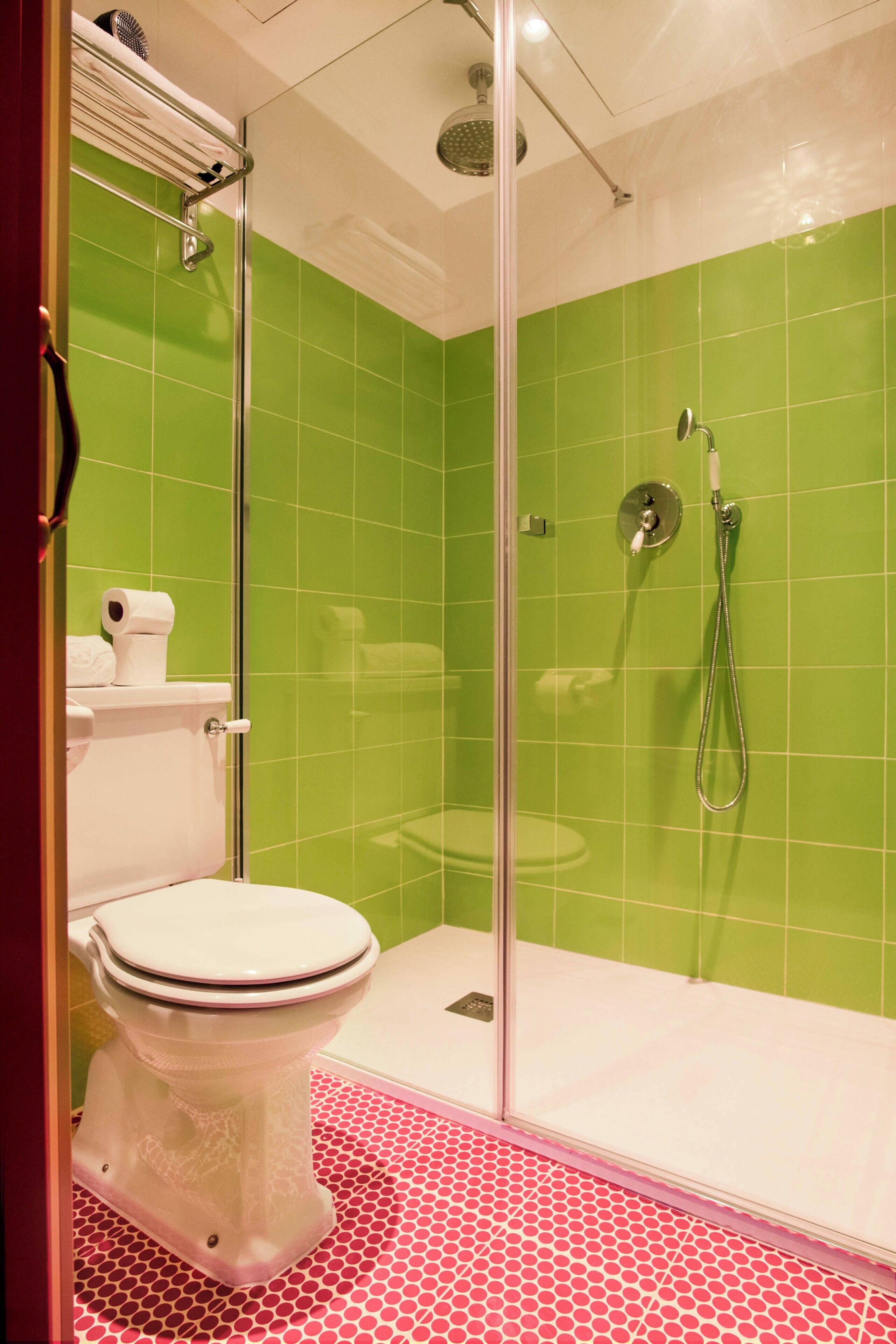 Un baño con ducha de vidrio, inodoro y lavamanos.