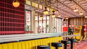A bar area with a yellow counter, black stools, and a patterned ceiling. - Romeos Ibiza - Adults Only (Sant Josep de sa Talaia)