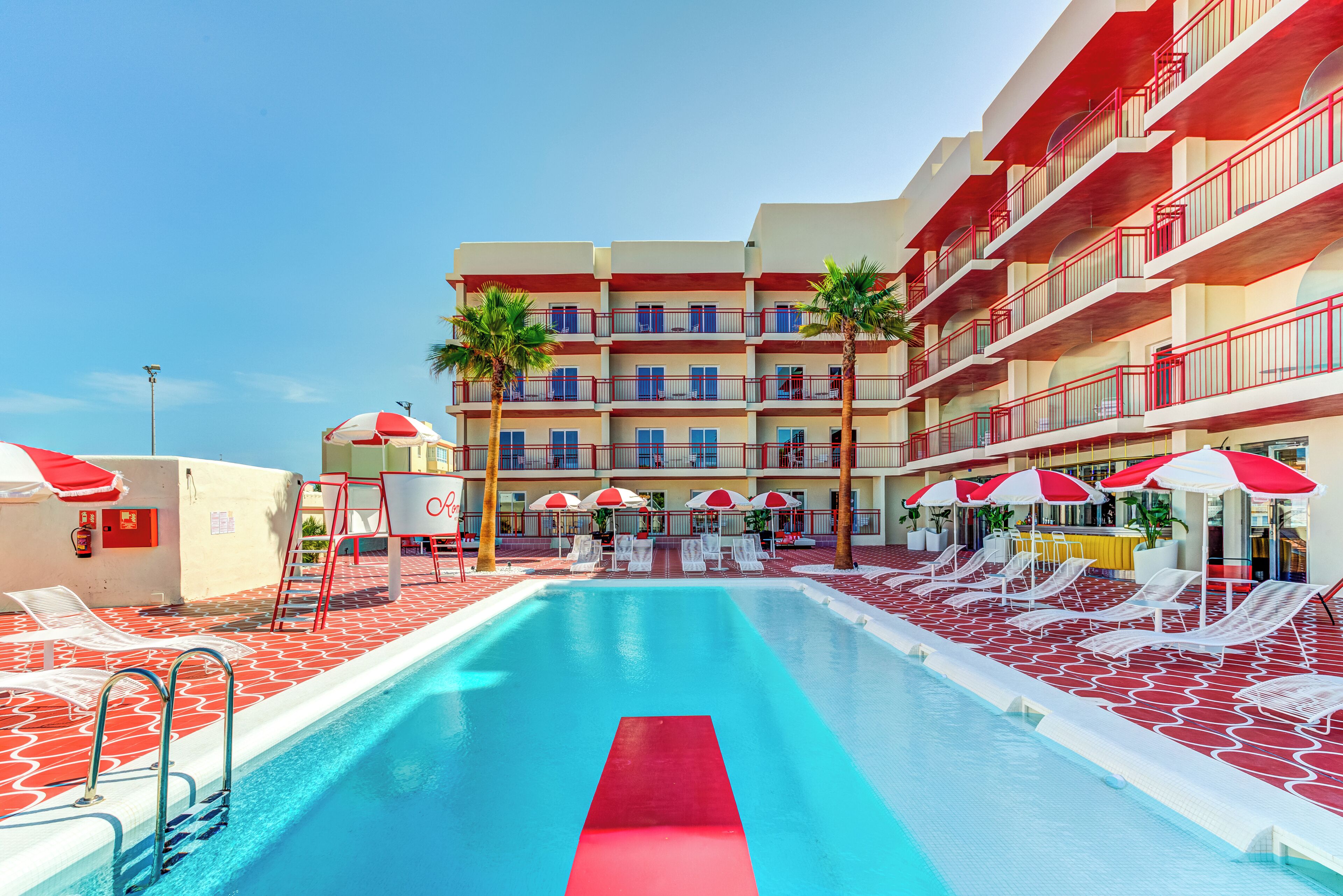 Una piscina al aire libre, sillones reclinables de piscina