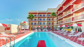 Una piscina al aire libre, sillones reclinables de piscina