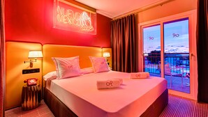 A hotel room with a bed, a neon sign, a telephone, and a balcony with a view. - Romeos Ibiza - Adults Only (Sant Josep de sa Talaia)