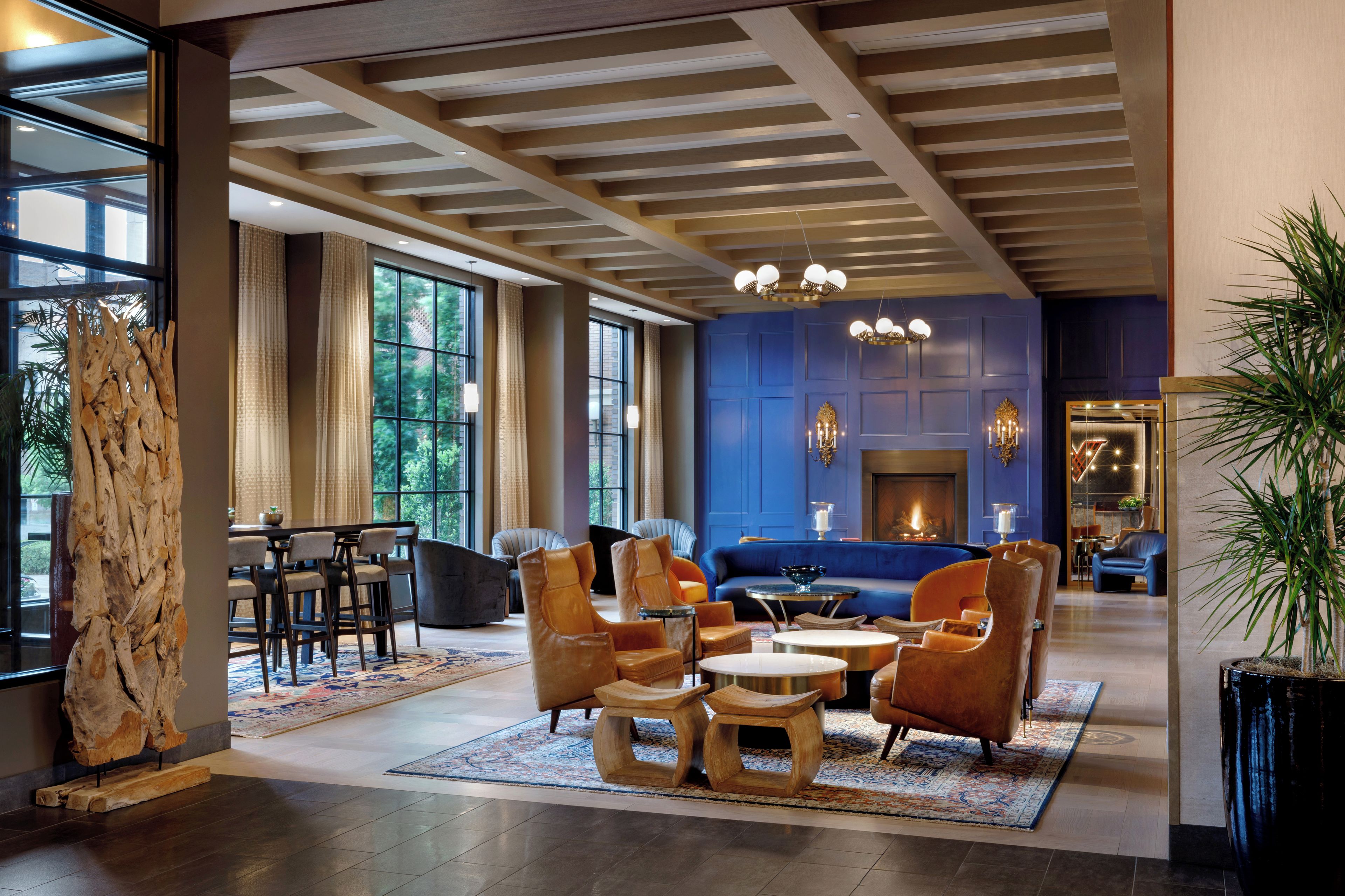 A spacious lounge area with a blue accent wall, a fireplace, and a variety of seating options including sofas and chairs.