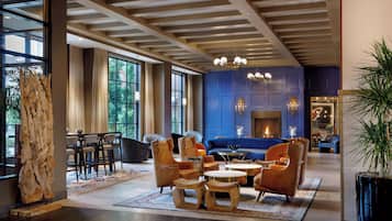 A spacious lounge area with a blue accent wall, a fireplace, and a variety of seating options including sofas and chairs.