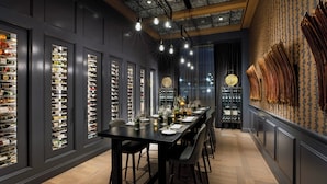 A long dining table with chairs, surrounded by shoe display cases and a patterned wall. - Hotel Vin, Grapevine, Autograph Collection (Grapevine)