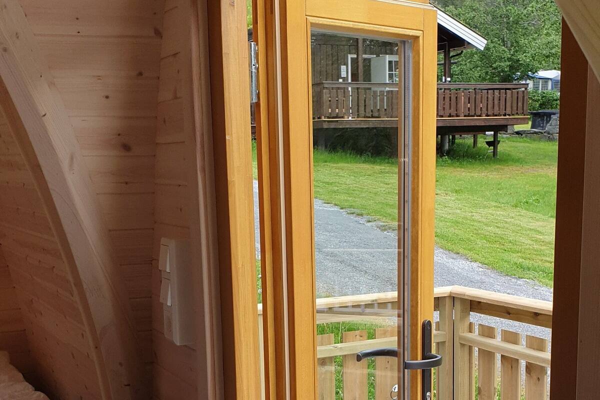Eine Holzhütte mit einer Schiebetür, die auf eine Terrasse im Freien führt.