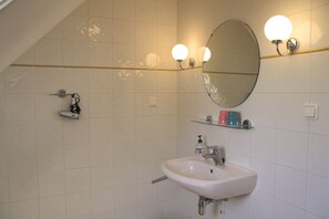 Regadera, secadora de cabello, papel de baño 