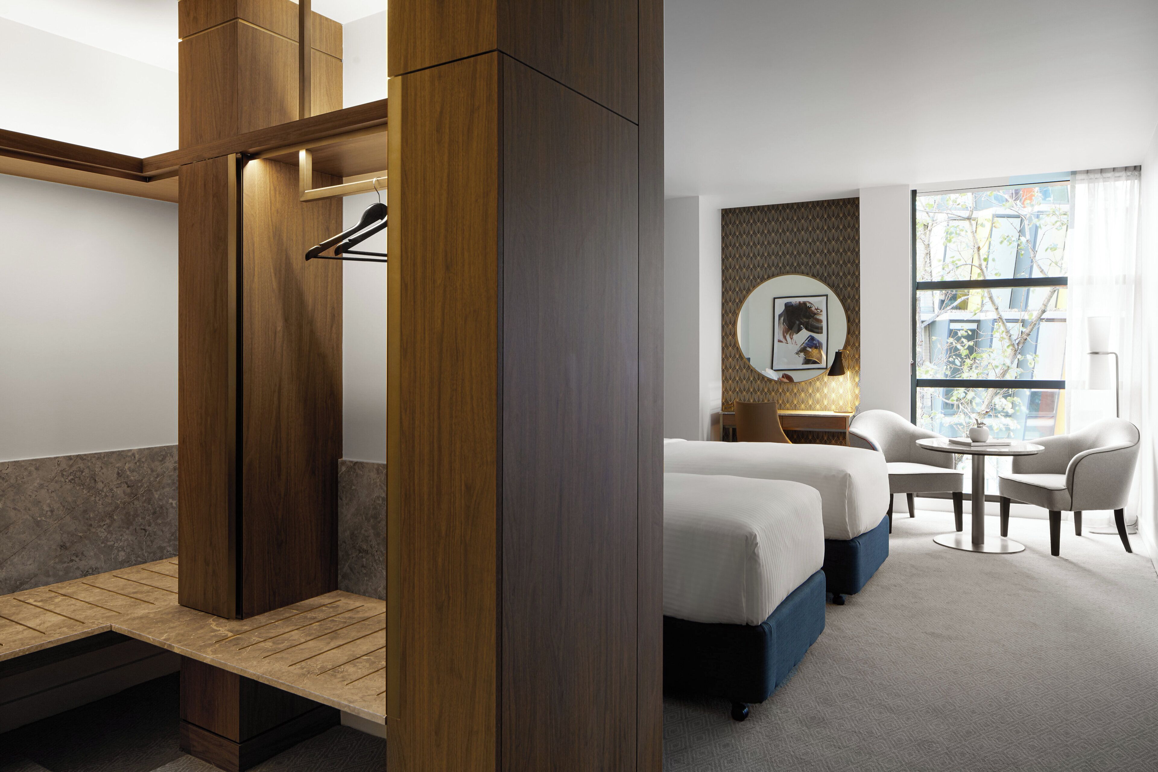 Een hotelkamer met een bed, een bureau, een stoel en een raam met uitzicht.
