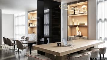 A modern conference room with a large table, chairs, and built-in shelving with decorative items.