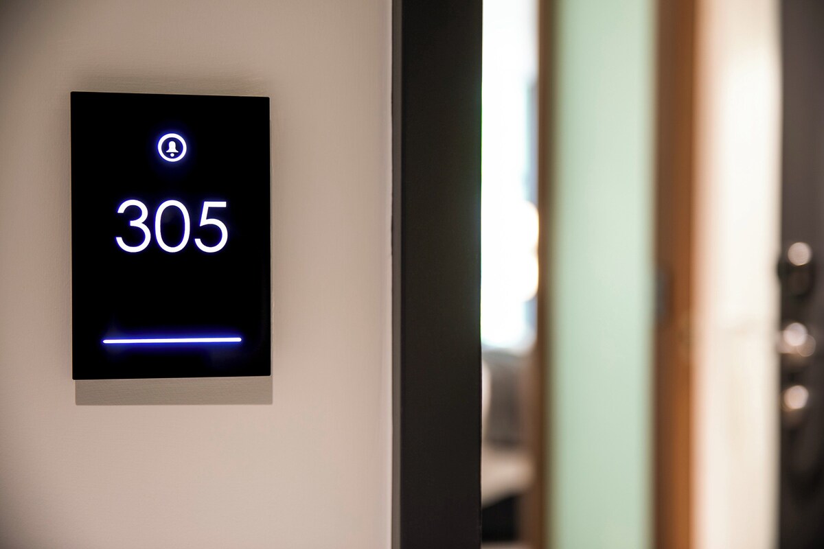 Een digitaal display met het nummer 305, dat een kamer of locatie aangeeft.