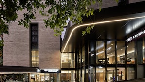 A modern building with a glass facade and a sign reading "CROWNE PLAZA".