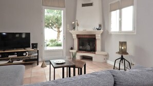 Un salon avec une cheminée, un téléviseur et un canapé.