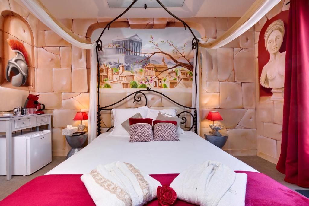 A hotel room with a bed, nightstands, a desk, and a mural on the wall.