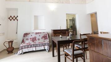 A dining area with a table, chairs, and a wooden cabinet.