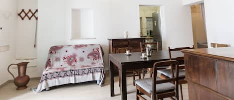 A dining area with a table, chairs, and a wooden cabinet.