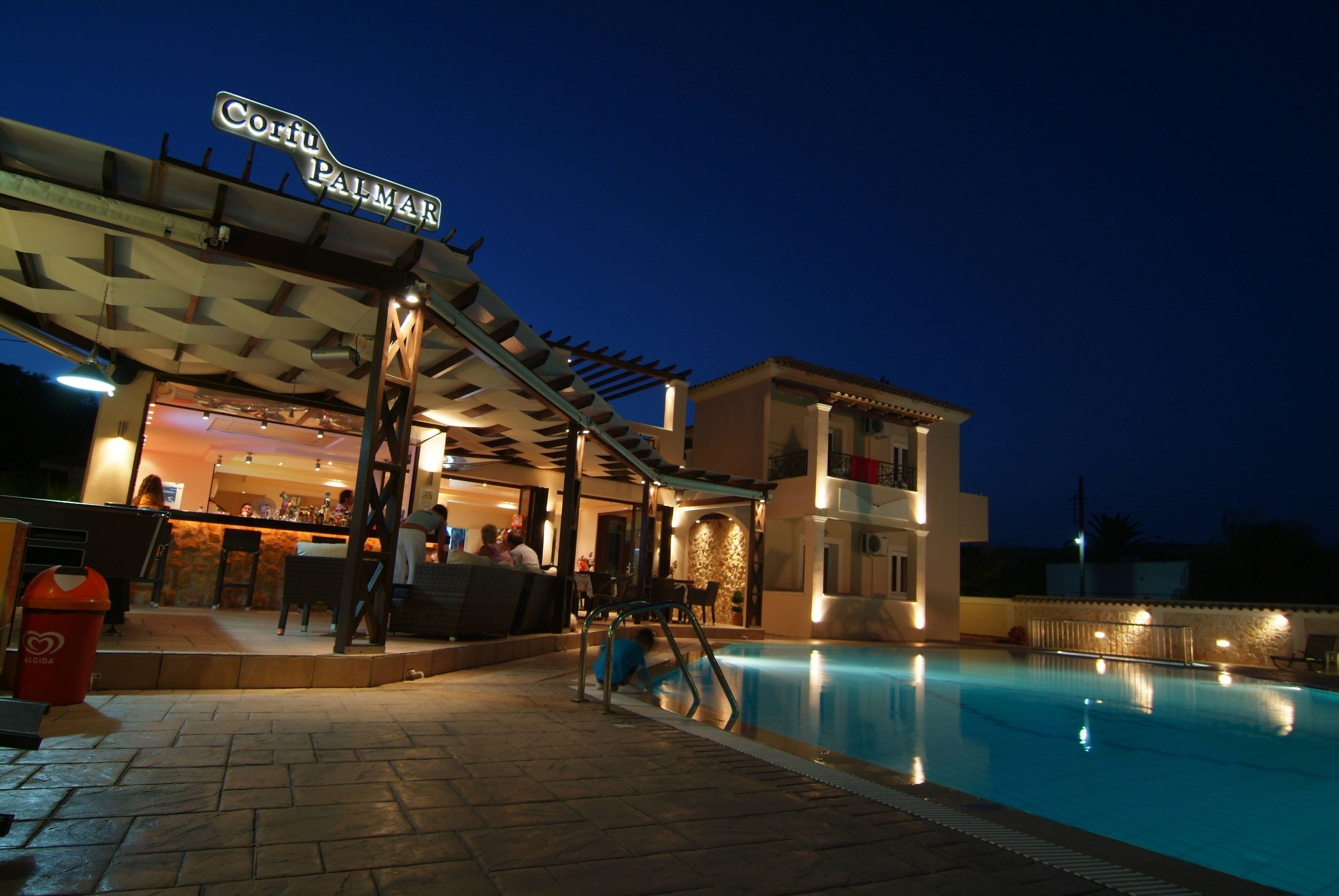 A hotel with a pool area, outdoor seating, and a bar.