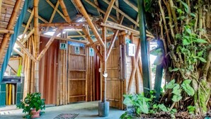 A bamboo structure with a thatched roof, wooden walls, and a central door. - Ecoturismo La Nohelia (Jericó)