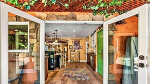 Un intérieur spacieux avec un mur en pierre, un plafond en bois et une porte verte.