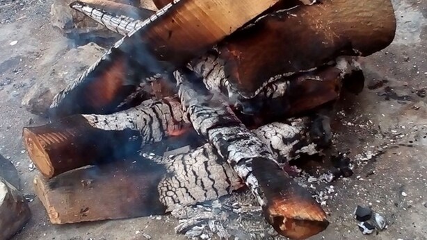 A metal kettle on a fire pit with burning wood. - Wadi Rum Moon Camp (Wadi Rum)