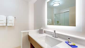 A modern bathroom with a white sink, a mirror, and a towel rack.