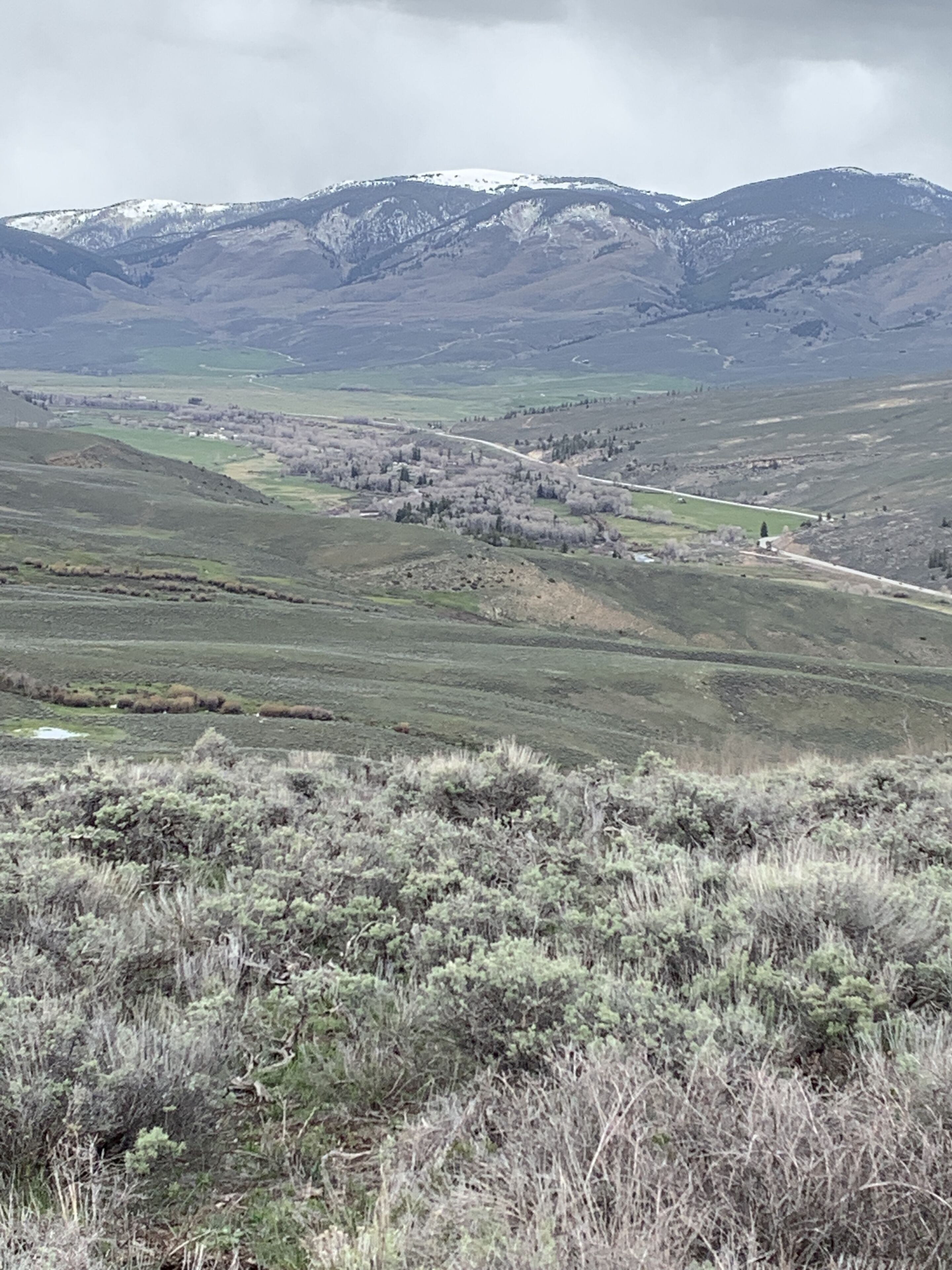 A mountainous landscape with a valley and a road running through it.