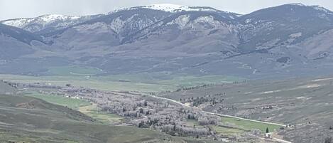 A mountainous landscape with a valley and a road running through it.