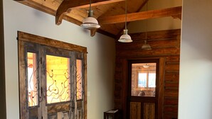 A wooden interior with a large wooden door, a bench, and a tiled floor. - Taylor Canyon Cabin in Almont (Almont)