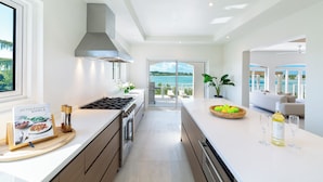 Cocina moderna con vista al océano, un ventanal grande y un comedor con vistas.