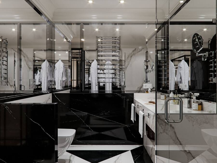 A modern bathroom with a black and white marble floor, a glass shower enclosure, and a large mirror.