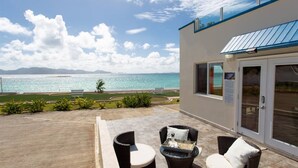 A patio with wicker furniture and a view of the ocean. - Flounder at Anguillitta (Blowing Point)