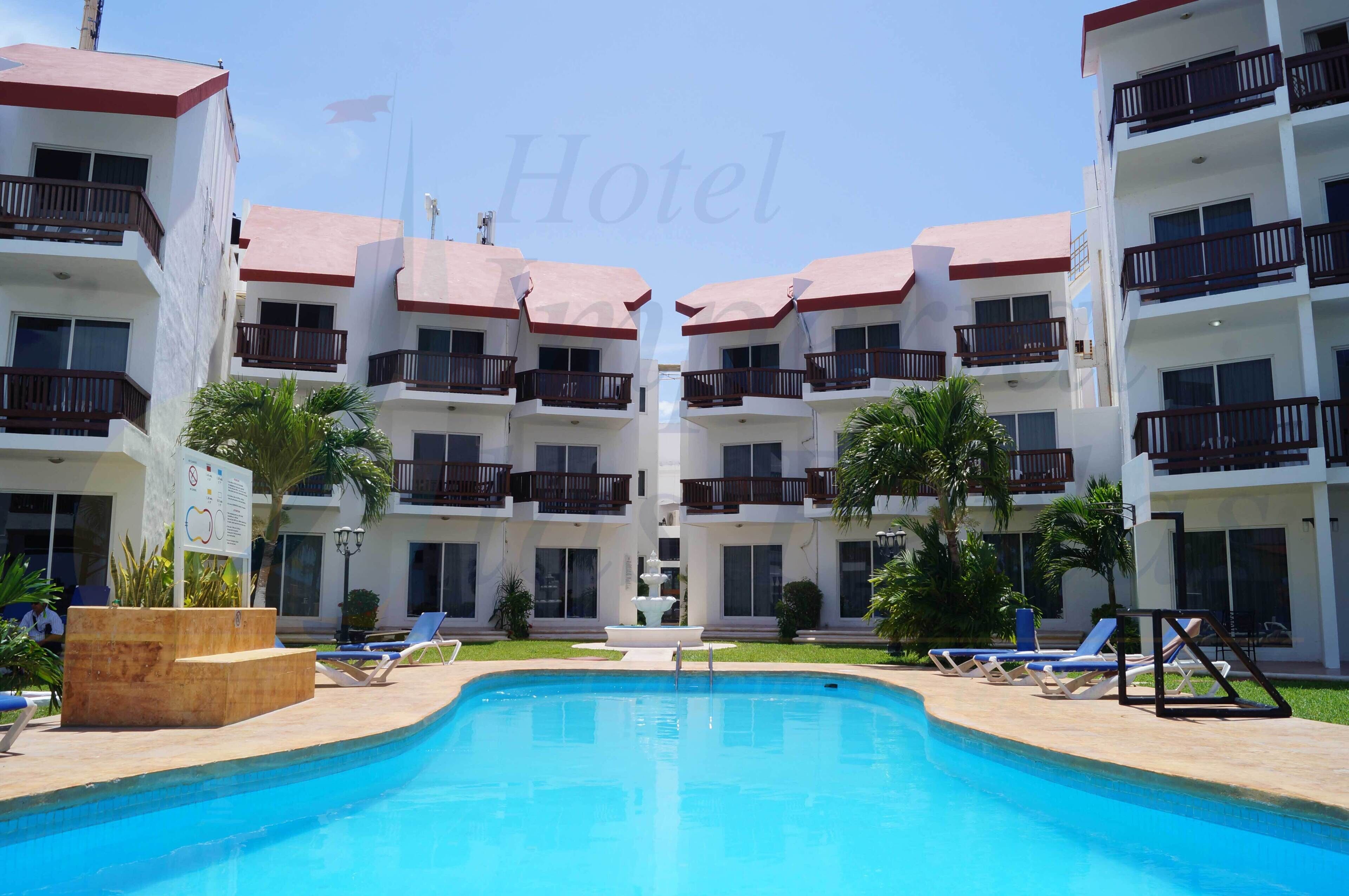 A hotel with a swimming pool, multiple balconies, and a fountain.