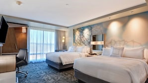 A hotel room with two beds, a desk, a chair, a TV, and a large window with curtains. - Courtyard by Marriott Bentonville Rogers Promenade (Rogers)
