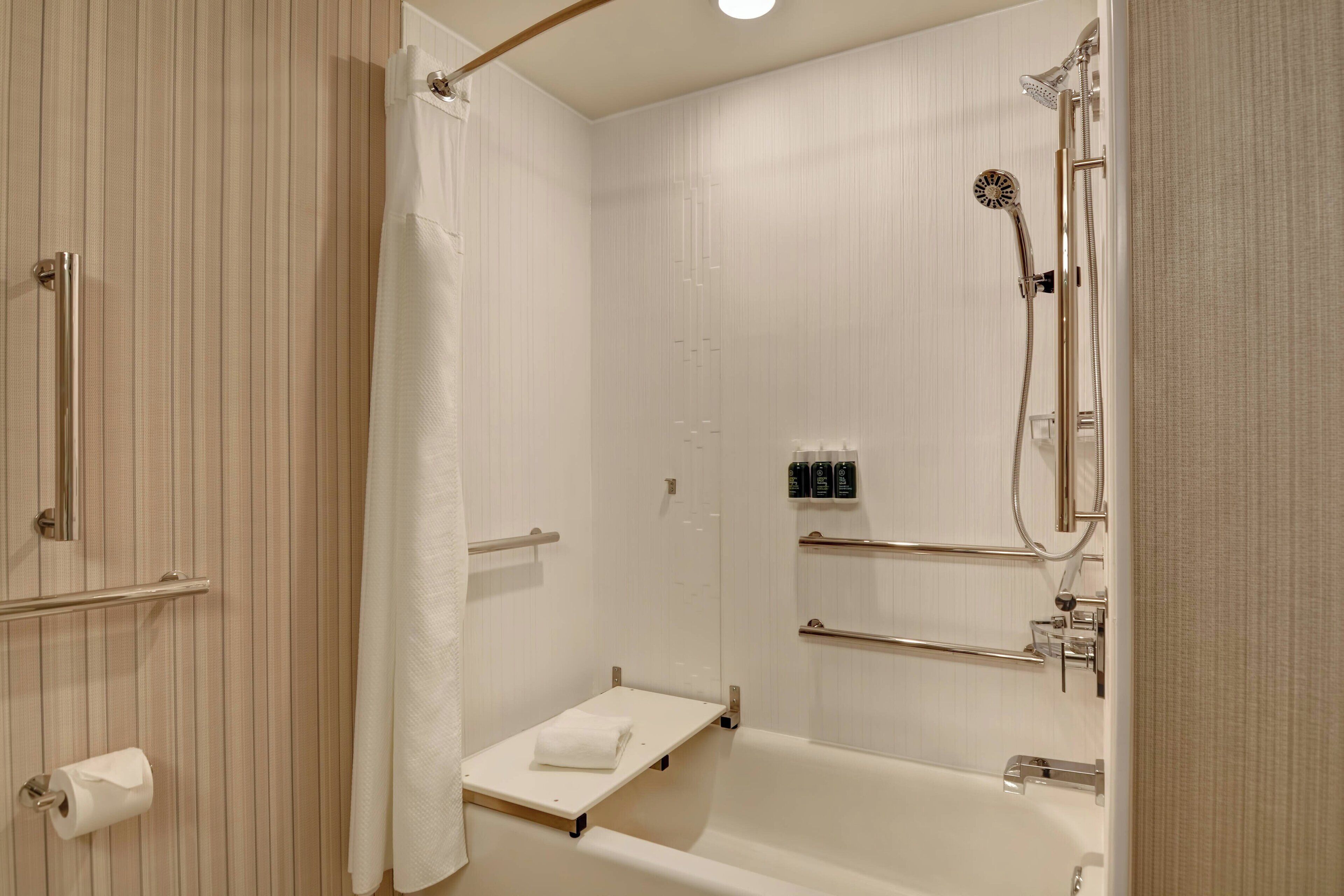 Une salle de bain moderne dotée d’une douche à l’italienne, d’une baignoire et de toilettes.