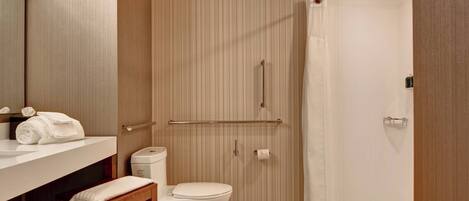 A modern bathroom with a toilet, sink, and shower area.